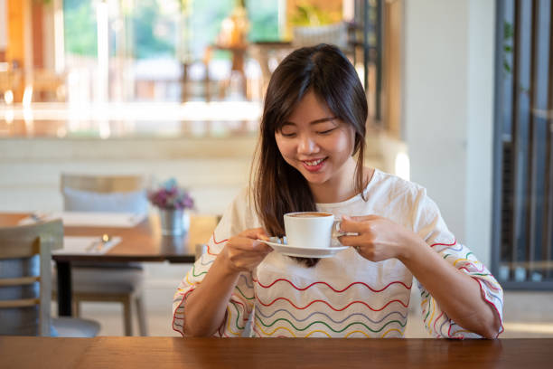 istock Young asian female having a coffee break in cafe 1198329239
