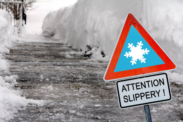 看板アテンション滑りやすい冬の凍った道! - road street sign slippery ストックフォトと画像