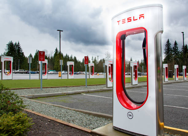 compresseur de tesla avec les nuages foncés de tempête au-dessus - supercharger photos et images de collection