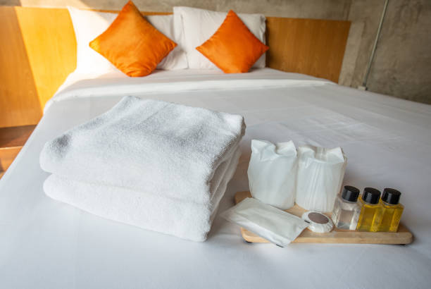 istock Set of hotel amenities (such as towels, shampoo, soap etc) on the bed. 1198346536