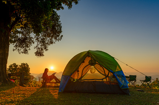 silhouette of woman traveller camping in campsite with freshly morning action