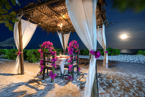 Romantic dinner on the beach at full moon. Gazebo on idyllic tropical beach (Zanzibar, Tanzania, Africa).