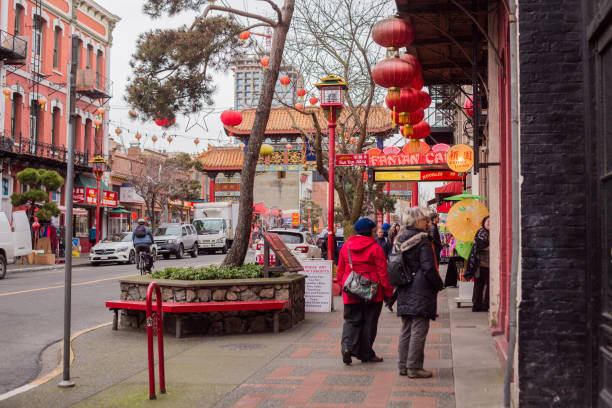 Victoria, Canada - December 17, 2019. Two people gaze into a window in Victoria's Chinatown.