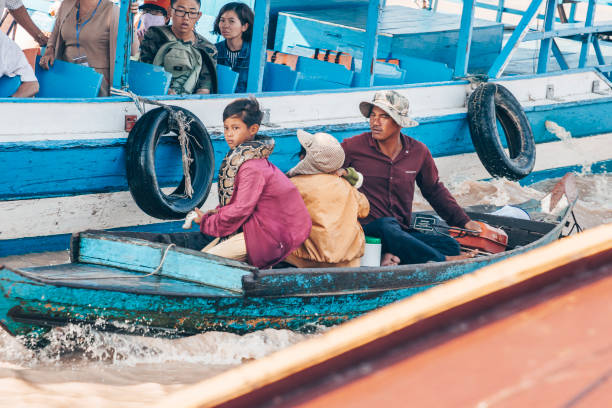 joven con gran serpiente pitón en el barco de madera en el lago tonle sap en camboya 2019-12-27. el pueblo flotante en el agua - water sap fotografías e imágenes de stock