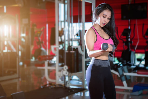 fitness mujeres asiáticas realizando ejercicios de entrenamiento con deporte mancuerna en el interior del gimnasio deportivo y fitness club de salud con equipo de ejerciciodeportivo gym fondo. - exercising sports training sport gym fotografías e imágenes de stock