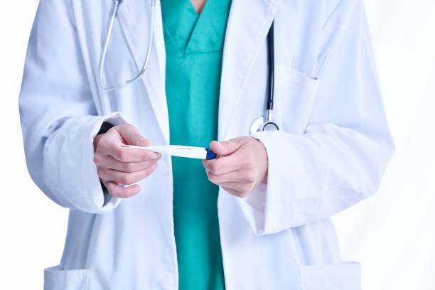 istock Standing doctor holding a digital electronic thermometer 1198362931