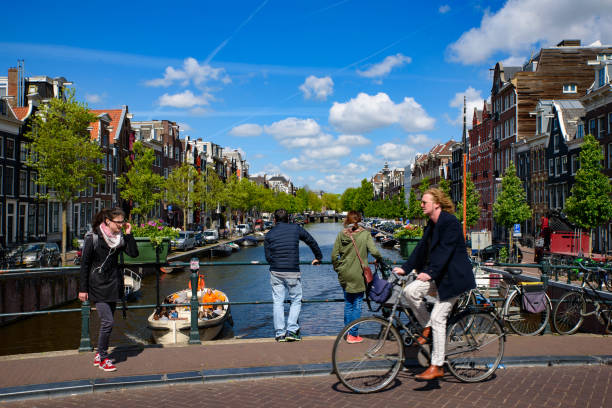 People riding bikes along the canal in Amsterdam, Netherlands