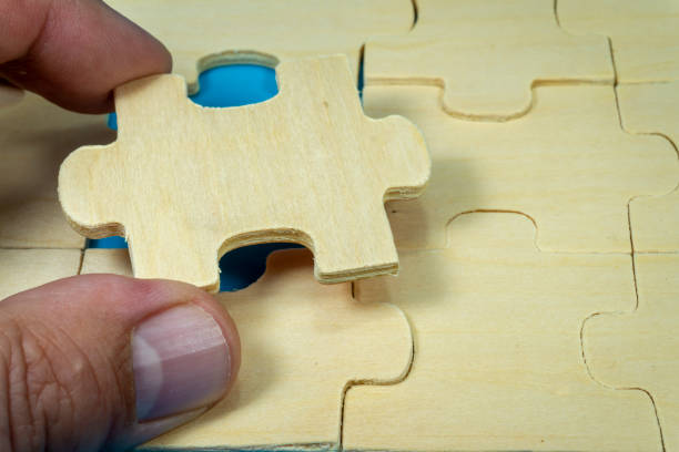 istock Puzzles with hand holding one piece taken out 1198366884