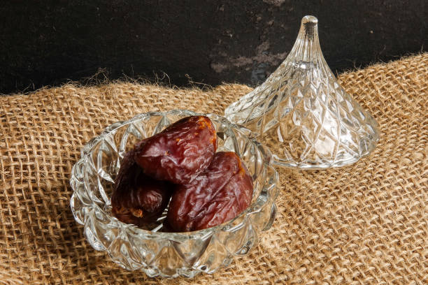 istock Date in a glass container on a rug background. 1198366932