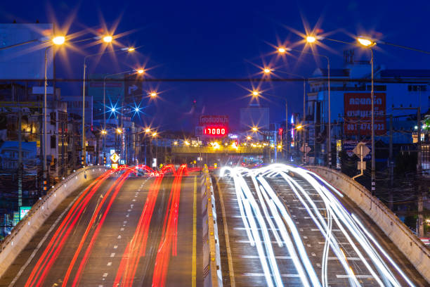 belle scène de la couleur des feux de circulation de nuit sur la route dans la ville de phitsanulok, thaïlande. - blurred motion bridge business blue photos et images de collection