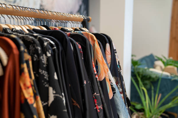istock Dark color designer kimonos hanging on cloths rack inside store 1198375519
