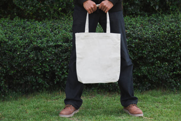 istock Man holding bag canvas fabric for mockup,ecology Concept. 1198375674