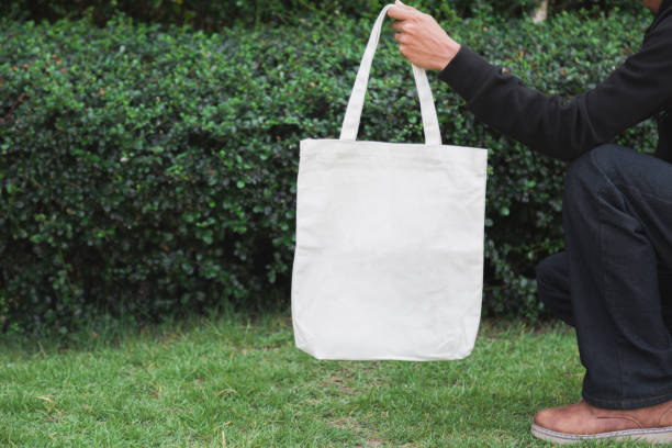 istock Man holding bag canvas fabric for mockup,ecology Concept. 1198375714