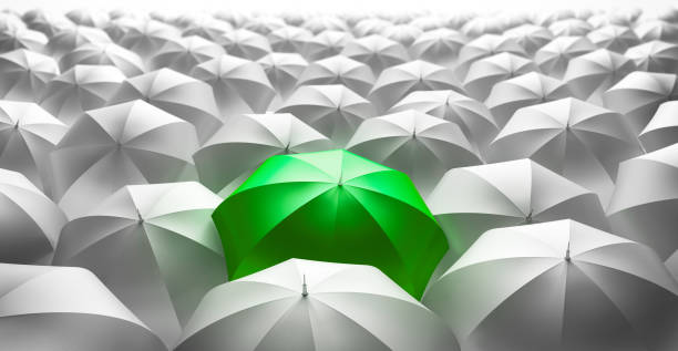 istock Crowd of Umbrellas with green Leader 1198377461