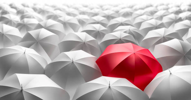 istock Crowd of Umbrellas with red Leader 1198378266