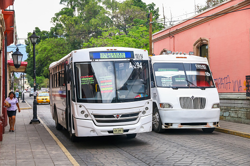 Oaxaca, Mexico - May 25, 2017: White urban buses in the city street.