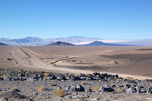 Landscape with volcanos in the background in the Puna de Atacama, Argentina. Puna de Atacama is an arid high plateau in the Andes of northern Chile and Argentina. In Argentina Puna's territory is extended in the provinces of Salta, Jujuy and Catamarca