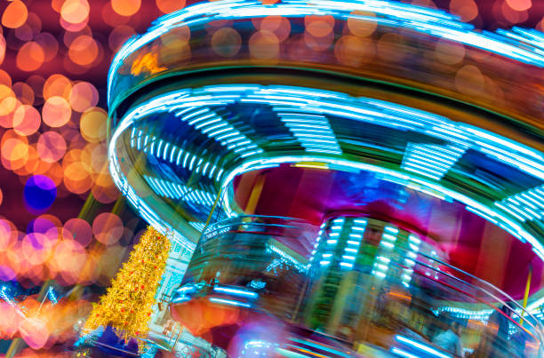 Colorful Christmas fair. Bright lights of night illumination and rotating carousel with motion blur stock photo