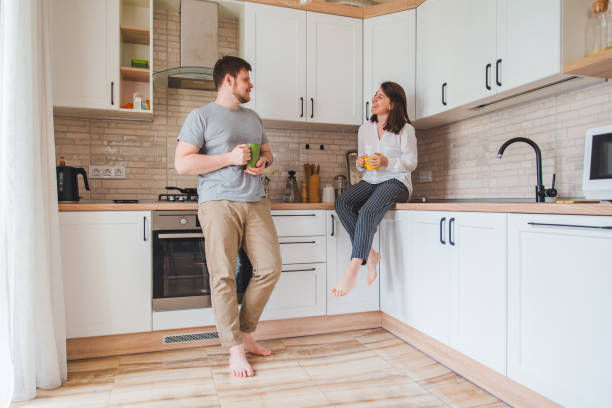 istock smiling man with woman at kitchen drinking tea 1198387943