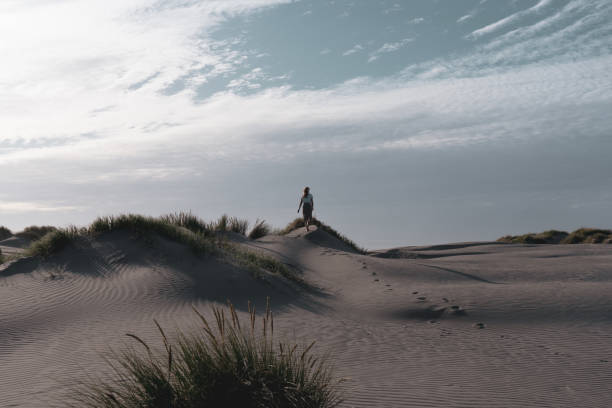istock A woman walking on the sand dunes 1198388104
