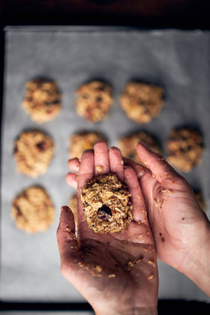istock Hands showing breakfast cookie dough prepared for baking in oven 1198388252