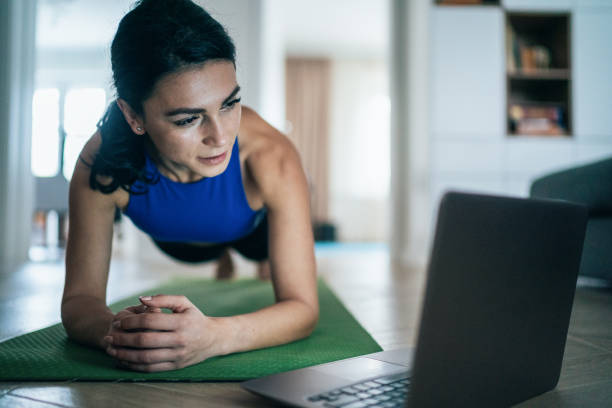 sporty woman doing plank - concentration flexibility full length healthy lifestyle imagens e fotografias de stock