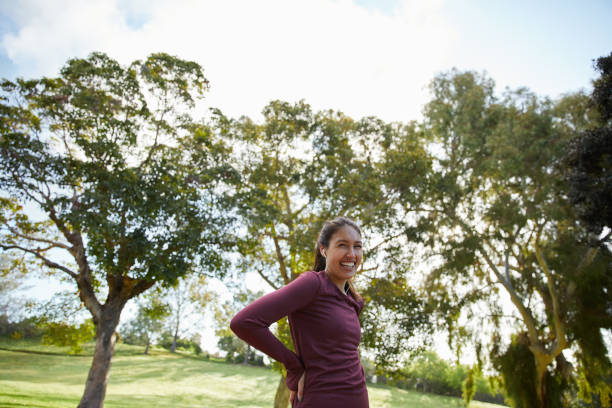 istock Smiling young woman taking a break from her run in a park 1198388469