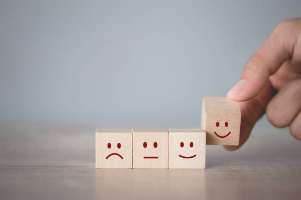 istock Customer pressing smiley face emoticon on wood cube, Service rating, satisfaction concept. 1198392445