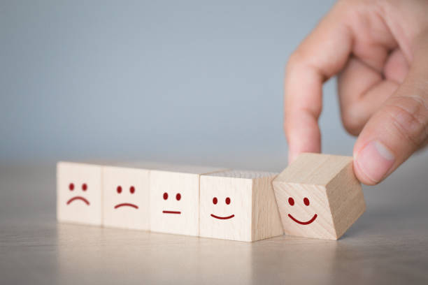 istock Customer pressing smiley face emoticon on wood cube, Service rating, satisfaction concept. 1198392486