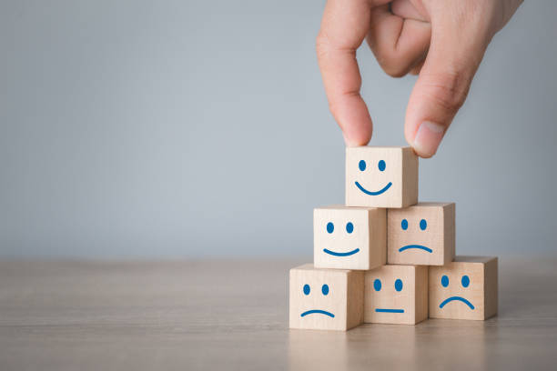 istock Customer pressing smiley face emoticon on wood cube, Service rating, satisfaction concept. 1198392526