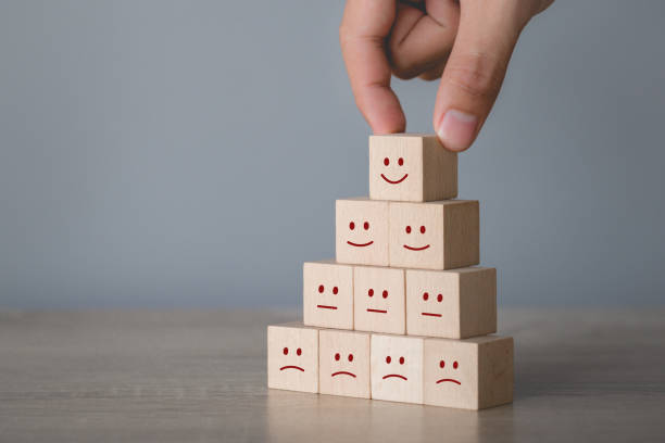 istock Customer pressing smiley face emoticon on wood cube, Service rating, satisfaction concept. 1198392613