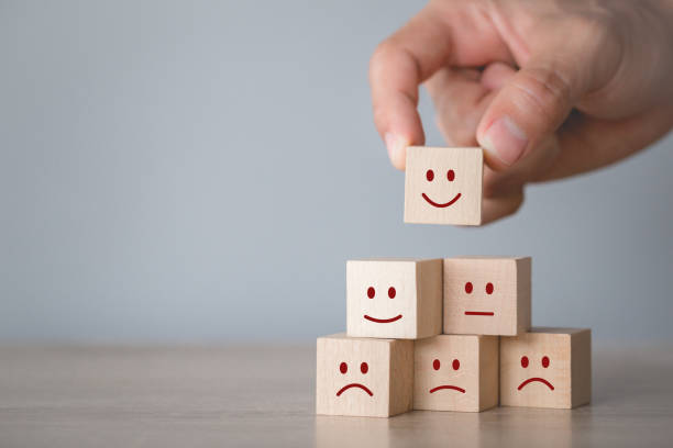 istock Customer pressing smiley face emoticon on wood cube, Service rating, satisfaction concept. 1198392618