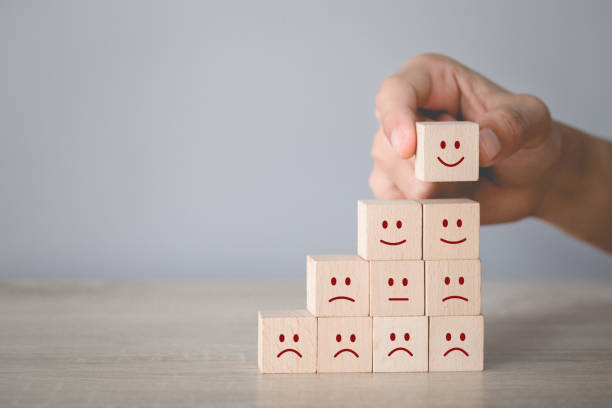 istock Customer pressing smiley face emoticon on wood cube, Service rating, satisfaction concept. 1198392643