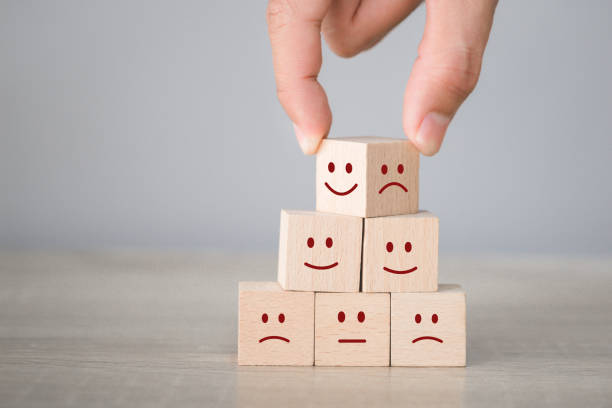 istock Customer pressing smiley face emoticon on wood cube, Service rating, satisfaction concept. 1198392752