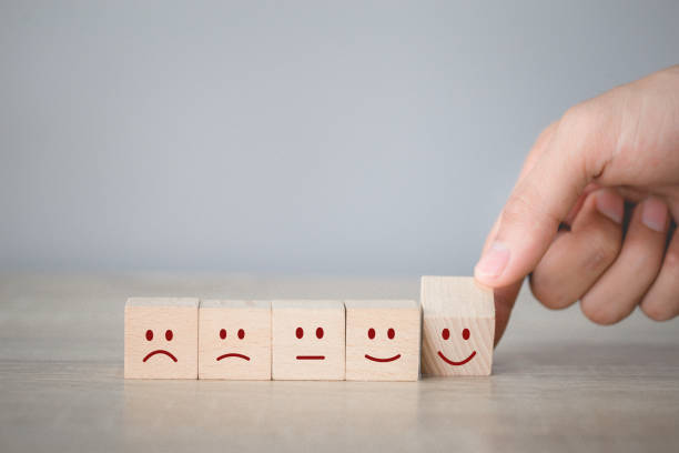 istock Customer pressing smiley face emoticon on wood cube, Service rating, satisfaction concept. 1198392758