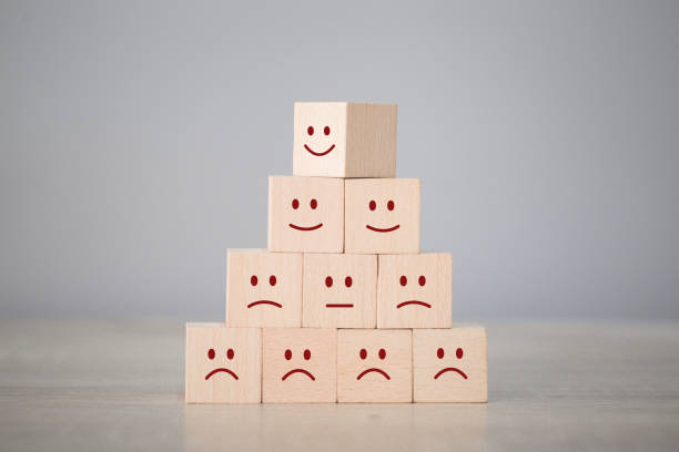 istock Customer pressing smiley face emoticon on wood cube, Service rating, satisfaction concept. 1198392772