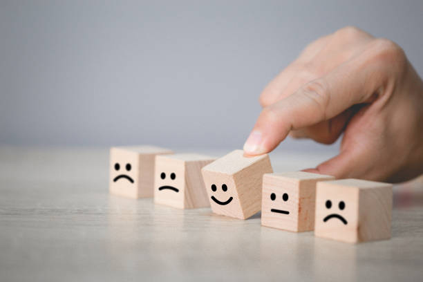 istock Customer pressing smiley face emoticon on wood cube, Service rating, satisfaction concept. 1198392825