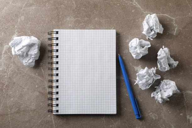 istock Paper balls, notebook and pen on grey table, top view 1198394155