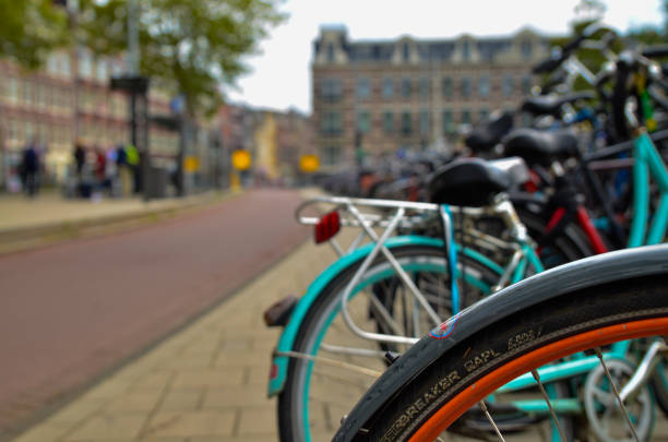 Amsterdam, the Netherlands, August 2019. Bikes parked on the sidewalk in the historic center: they are a city corner. The frames create a kaleidoscope of colors.