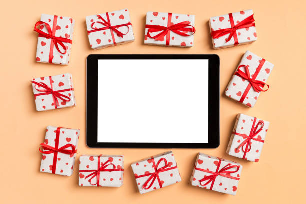 istock Top view of digital tablet surrounded with gift boxes on colorful background. Saint Valentine's day 1198396996