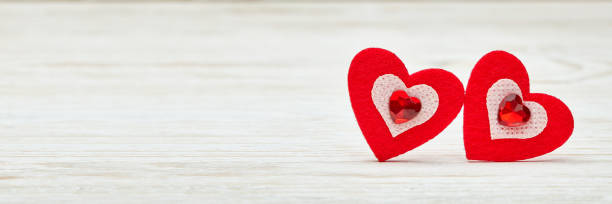 istock Two decorative hearts on light wooden background. Copy space. Valentine's Day card. Extra wide panorama banner background 1198397132