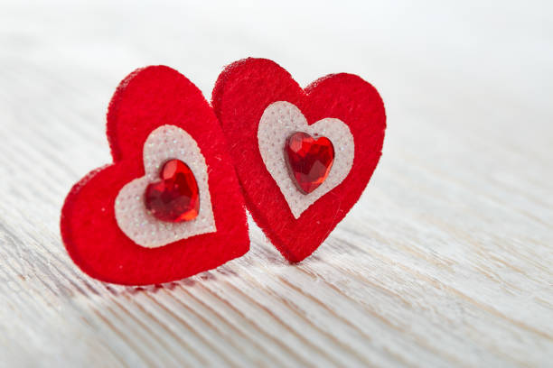 Two decorative hearts  on light wooden background. Valentine's Day card. Design element for romantic greeting card, wedding invitation,