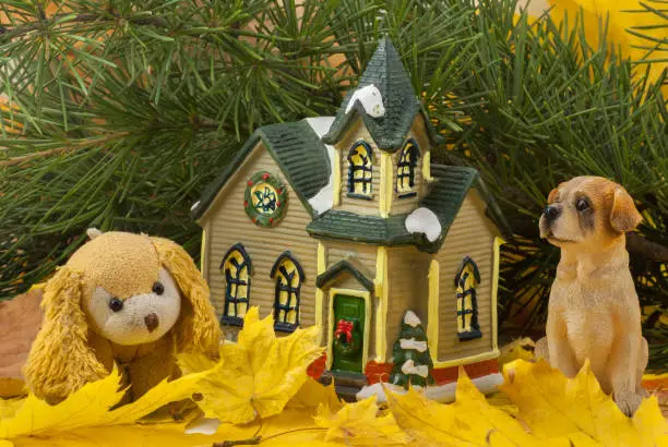Photo of Autumn composition. cute toy dogs. dried bright autumn leaves, small toy house. Close up