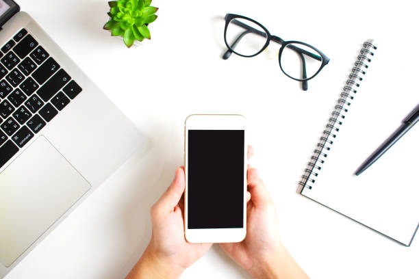 istock The top view holds a black screen smartphone on a modern working table. 1198398808