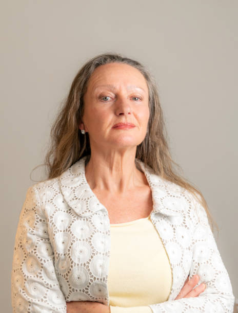 istock Mature woman with jacket on a grey wall 1198400703