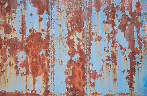 High resolution photograph of a rusty blue painted steel plate.