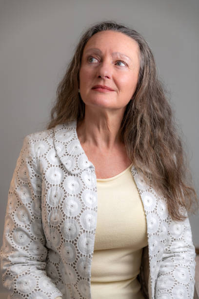 istock Mature woman with jacket on a grey wall 1198400770