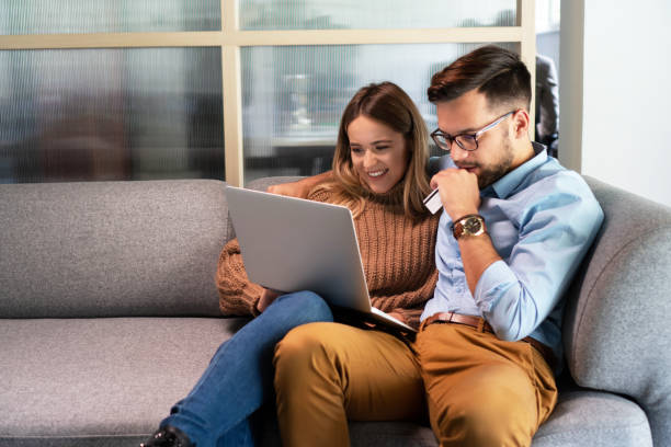 istock Young couple ordering online, looking in laptop 1198401499