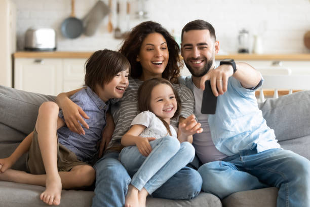 istock Couple and little kids making selfie using smart phone 1198401597
