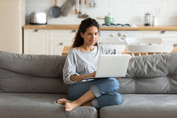 Female holding on lap notebook looking at screen writing email